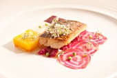 Close-up of whitefish fillet with colourful dressing on plate