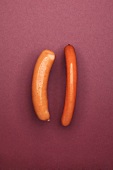 Sausage and frankfurters on maroon background