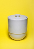 Close-up of white storage container on yellow background