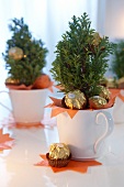Christmas sapling decorated with chocolate balls in white pot