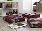 Living room with book cabinet, wicker chair and red flannel plaid cushion
