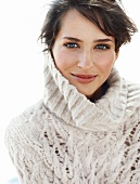 Portrait of pretty blue eyed brunette woman in white turtleneck sweater in winter, smiling