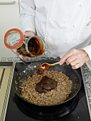 Geflugel juice being added to duck liver and mushroom in pan