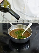 Red wine being added to refine Bolognese with herbs in plan