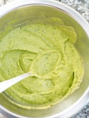 Close-up of avocado cream in bowl with spoon in it