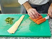 Close-up of man's hands chopping meat with knife on cutting board