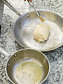 Butter being applied with brush on wrapped sole roulade