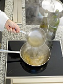 White wine sauce being poured in pan