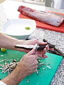 Black salsify's skin being peeled off with a peeler