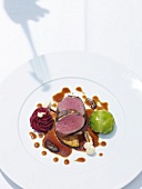Venison with walnuts, cabbage balls and beetroot puree on plate