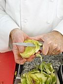 Artichoke being cut with knife