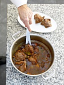 Veal cheeks being removed from pan
