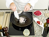 Sauteing onions in frying pan, elevated view