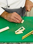 Slicing white asparagus to pieces