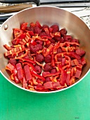 Chopped red bell pepper and raspberries in pan