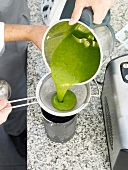 Pouring basil paste on strainer