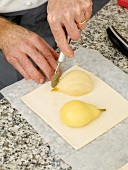 Soaked pear placed on puff pastry and cutting excess of pastry puff