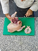 Cutting chicken on chopping board