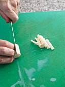 Close-up of salsify sticks being sliced