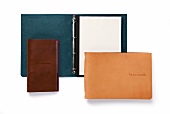 Close-up of leather wallets and paper moles on white background