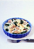Spinach and mushroom gratin in blue baking dish