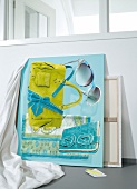 Close-up of bag, sunglasses, silk scarf and belt on turquoise colour
