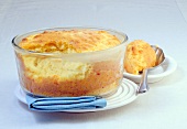 Airy cheese souffle in glass bowl on plate
