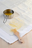 Spreading butter with brush on phyllo sheets for preparation of red cabbage strudel
