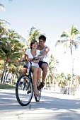 Couple having fun while bicycle riding, laughing