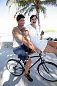 Paar hat Spaß auf einem Rad sie sitzt auf Lenker
