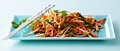 Soya sprout salad with chicken and vegetable strips in serving dish with chopsticks