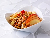 Soy cereal with honey, nuts and apple in bowl