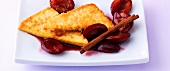 Close-up of crumbs and cinnamon tofu with red plums on plate