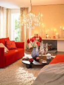 Living room with red sofa, fur carpet, lit candles and chandelier