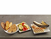 Grilled bread, grilled cheese and grilled vegetables with banana on plates