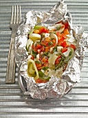 Grilled vegetables with herbs and cheese on foil