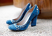 Close-up of blue suede pumps with block heels and rivets