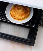Pancakes on plate being kept in oven