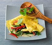 Sesame crepes with vegetables and coconut milk on plate