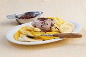 Pineapple and mango salad with ginger chocolate cream on plate