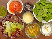 Various ingredients and dressings for salad in bowls