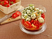 Salad with tomatoes and mint balls in glass container