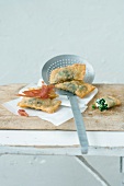 Fried Spinach Ravioli with cheese on slotted spoon