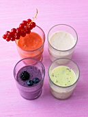 Four different berry shakes in glasses