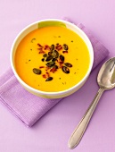 Bowl of pumpkin soup on folded napkin