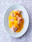 Salmon pieces in carrot cream on plate