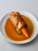 Turkey roulade with whole carrot on plate