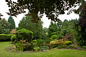 View of garden with natural pond, gazebo, spruce in Beverstedt, Lower Saxony
