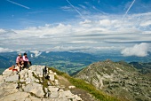 Two mountain guide sitting at Nebelhorn mountain overlooking Allgau Alps in Germany