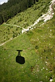 Shadow of cable car on green field near Oberstdorf, Germany